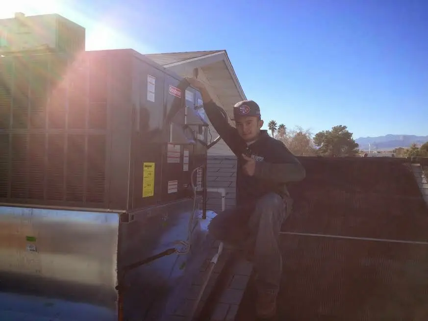 HVAC technician performing HVAC Inspection on a rooftop unit in Keene